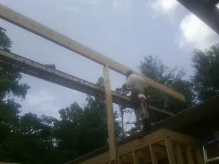 Carpenter setting a ridge beam over a new addition frame — Ice Dam Removal by Roofing Brothers in Yuba City