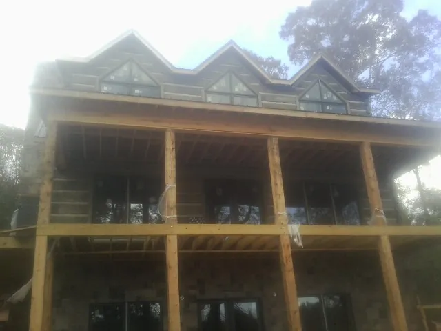 Dormers and porch framing on a large log home under construction — Roof Coating work by our crew in Yuba City