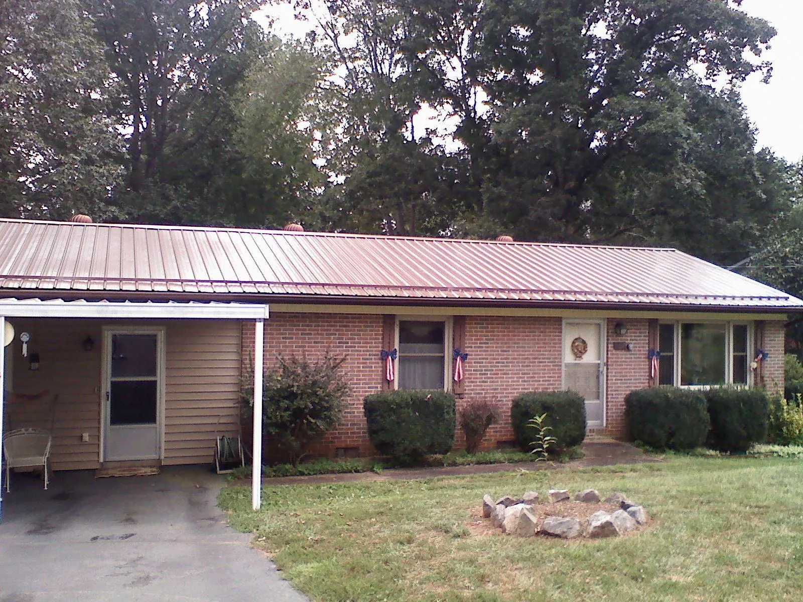 Bronze metal roof and carport on a brick ranch home — Roof Repair work by our crew in Yuba City